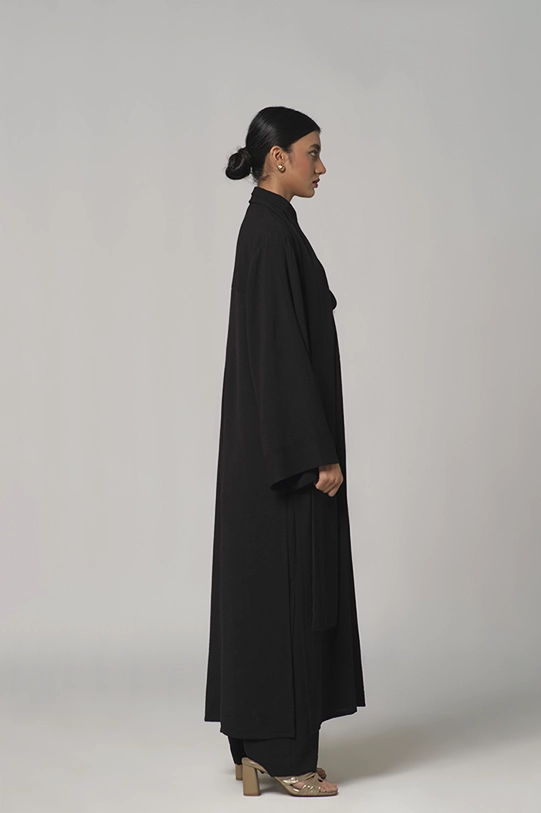 Black oversized shirt paired with wide-leg pants.