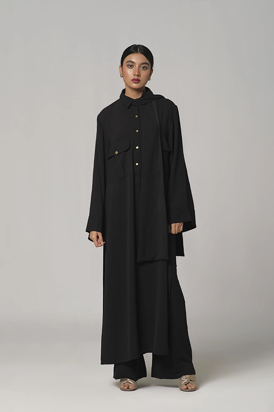 Black oversized shirt paired with wide-leg pants.