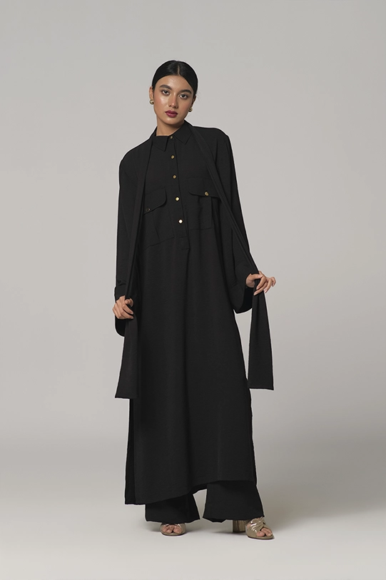 Black oversized shirt paired with wide-leg pants.