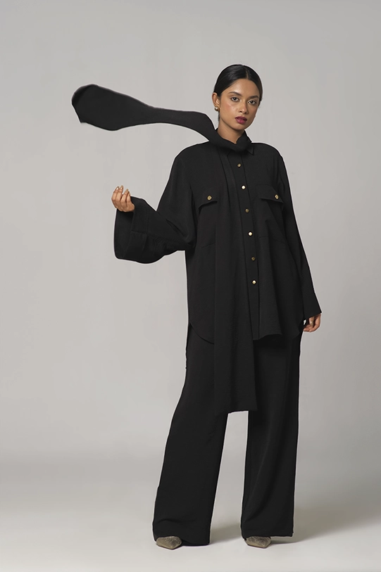 Black oversized shirt paired with wide-leg pants.