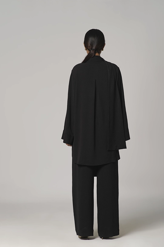 Black oversized shirt paired with wide-leg pants.